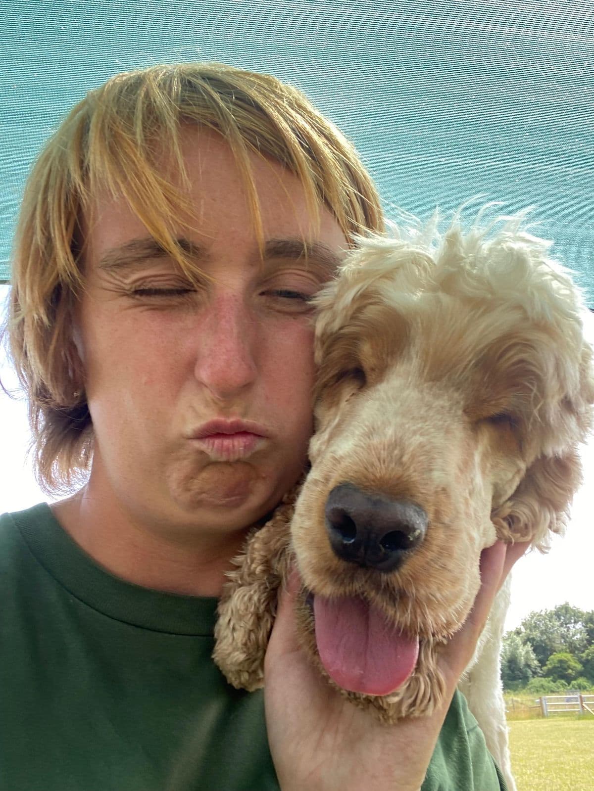 Dog day care staff member posing with a happy golden Cocker Spaniel